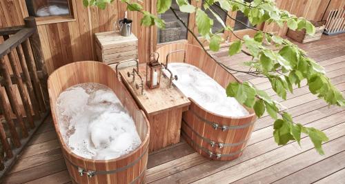 a bathroom with two barrel tub and a sink at The Fish Hotel in Broadway