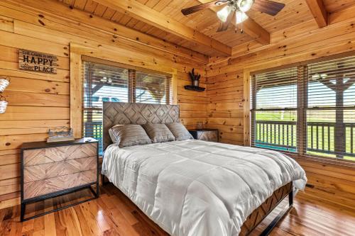 una camera con un letto in una baita di tronchi di Private Lake Hot Tub Fire Pit 5 Min to Hollerwood a Campton