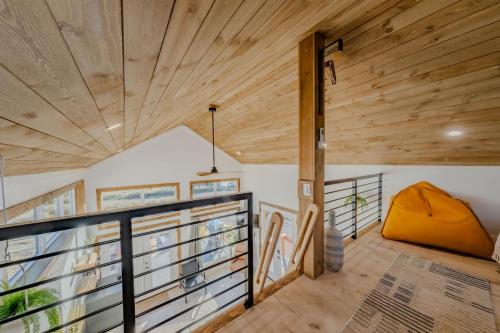 a room with wood ceilings and a balcony with a couch at Stargazing Retreat with Hot Tub Deck Hammocks BBQ in Glendale