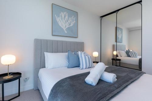 Un dormitorio con una cama con almohadas azules y blancas. en Perfect Escape Wake Up to Stunning Harbour Views, en Melbourne