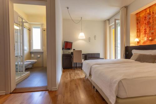 a bedroom with a large bed and a bathroom at Hotel Meridiana in Malcesine