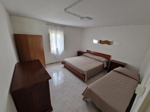 a bedroom with two beds and a table and a desk at Casa Alba Paestum in Paestum