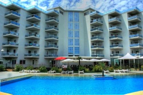 a large hotel with a swimming pool in front of it at Elena Club Resort in Silvi Marina