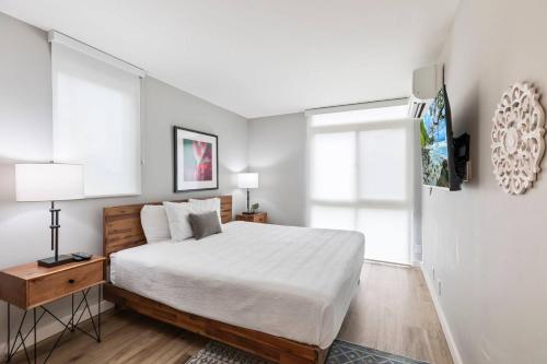 a bedroom with a bed and two windows at Beachfront Condo in Kihei in Kihei