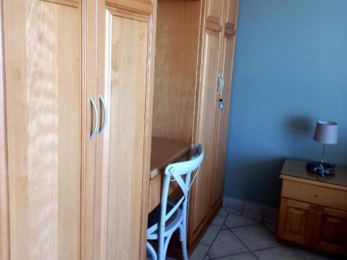 a desk with a chair next to a wooden cabinet at Waves of Mercy in Trafalgar