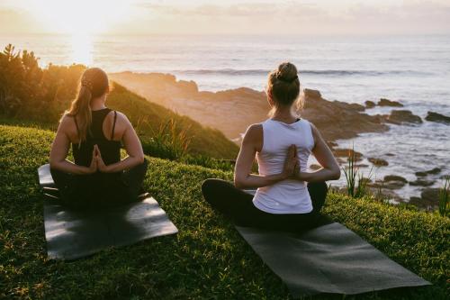 two women sitting on a hill with the ocean at Sala Beach House in Ballito
