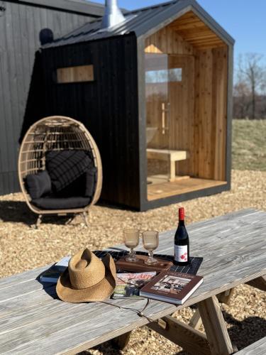 a picnic table with a bottle of wine and a hat at The Retreat on the Ranch (INSANE VIEW) in Gap