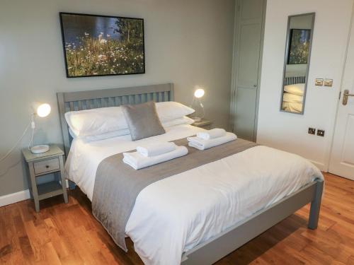 a bedroom with a bed with two towels on it at Chestnut in Cowbridge