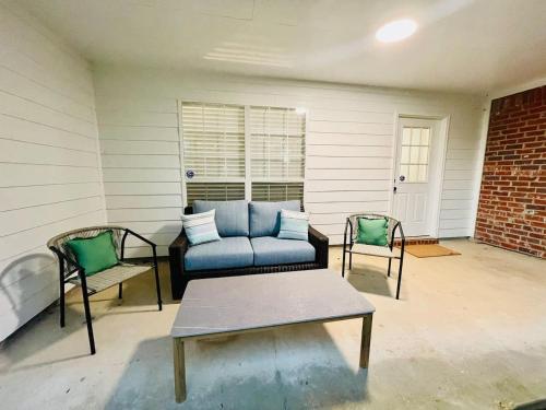 a patio with a blue couch and two chairs at Eastgate 10A beautiful townhouse in Hammond
