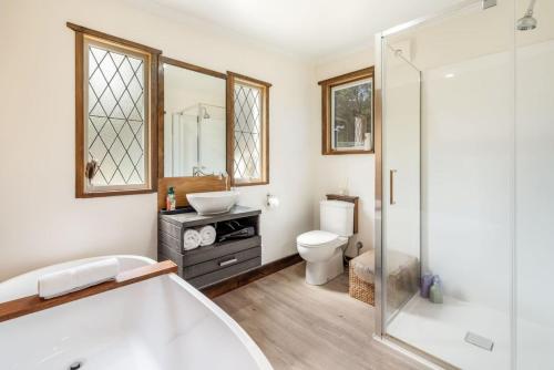 un bagno con vasca, lavandino e WC di Secluded Huon Valley Lodge with Hot Tub and Cottage a Lymington