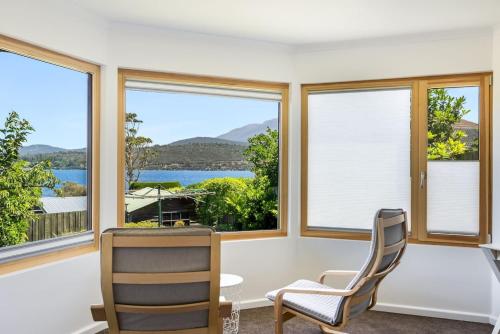a living room with windows and a table and chairs at Stylish Studio with Stunning Views in Lindisfarne