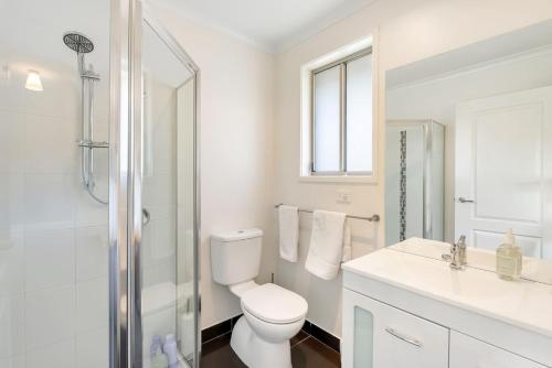 a white bathroom with a toilet and a shower at Modern and Spacious Howrah Home in Howrah