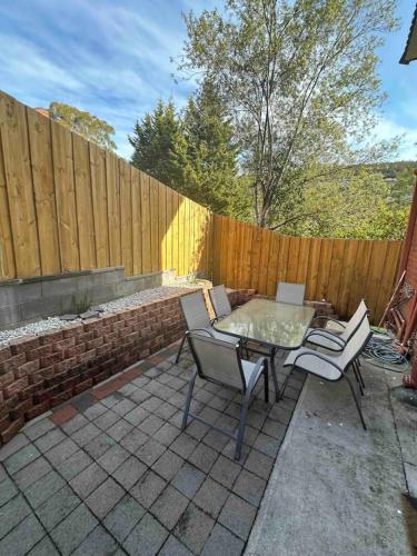 a patio with a table and chairs and a fence at Renovated two-level Sandy Bay apartment in Sandy Bay
