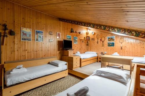 Una habitación con tres camas y un televisor. en Tonale Sky Attic - Ponte di Legno by InnStay, en Ponte di Legno