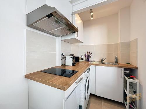 une cuisine avec des armoires blanches et un comptoir dans l'établissement Studio Cozy - Gare Saint Charles - Les Frères de la Loc', à Marseille