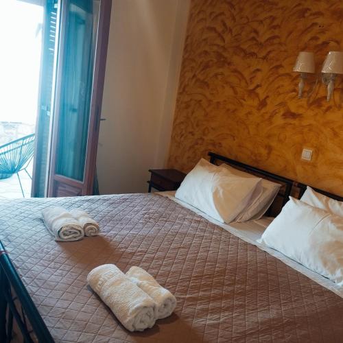 a bedroom with a bed with towels on it at Iridis R & R in Ligaria