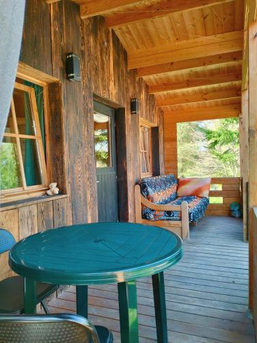 a porch of a cabin with a table and chairs at Agroturystyka Camilleri in Młynary