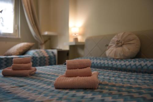 a bed with two stacks of brown towels on it at casa vacanze La Farfalla in Capo dʼOrlando