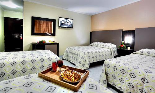 a hotel room with two beds and a tray of food at Hotel Marbella in Panama City