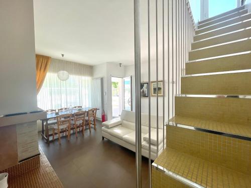 Una sala de estar con escalera y un comedor. en Villa Dolce Rumore, en Bari