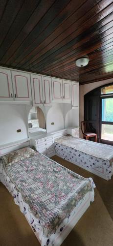 a bedroom with two beds and a wooden ceiling at Hospedaria Soraya Alegre in Campina Grande do Sul