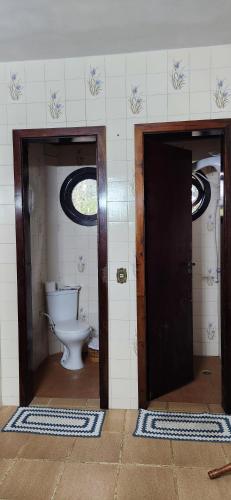 a bathroom with two doors and a toilet at Hospedaria Soraya Alegre in Campina Grande do Sul