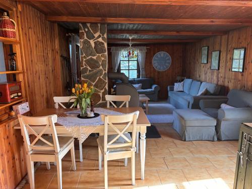 a dining room and living room with a table and chairs at Chata u rybníka Machčák in Třebušín