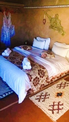 a bedroom with two beds with white comforters at DAR Moha dades in Aït Ougliff