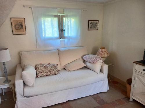 a white couch with pillows on it in a room at La Maisonnette de la Danasha in Viglain
