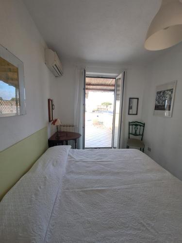 a bedroom with a large white bed and a window at Home sweet home in Ischia