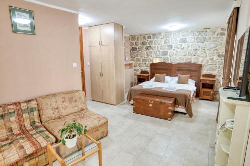 a living room with a bed and a couch at Hotel Rendez Vous in Kotor