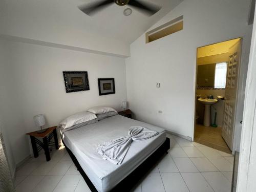 a white bedroom with a bed and a sink at Descansa en familia en Rio Bonito lleva tus mascotas in Melgar