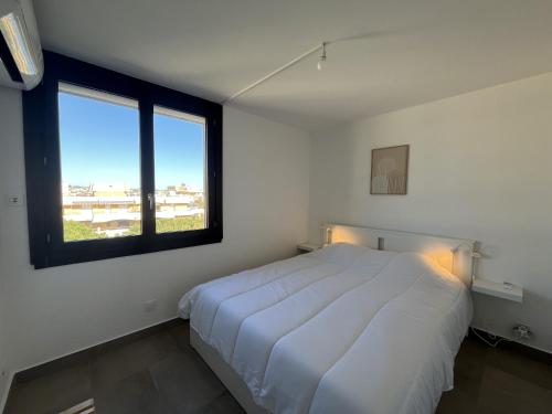- une chambre avec un lit blanc et 2 fenêtres dans l'établissement LA MIOUGRANO T3 etat neuf 5-6p, climatise, 300m de la, à Fréjus