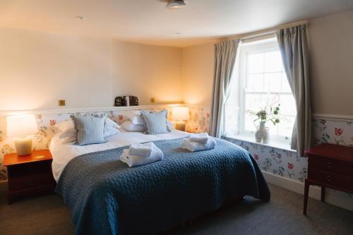 a bedroom with a bed with towels on it at The Market Tavern in Bampton