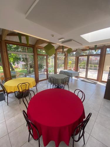 une salle à manger avec tables, chaises et fenêtres dans l'établissement La Brise de Mer, à Saint-Michel-Chef-Chef