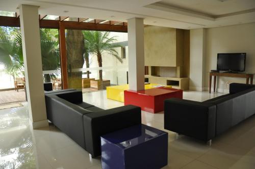a living room with couches and a tv at A Furninha Hotel in Torres