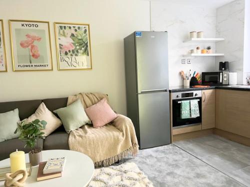 ein Wohnzimmer mit einem Sofa und einem Kühlschrank in der Unterkunft Artistic 2 bed flat in Bolton City Centre in Bolton