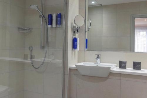 a bathroom with a sink and a shower at Crowne Plaza East Midlands Airport by IHG in Derby