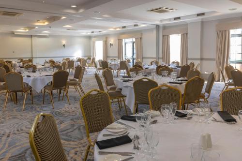 a conference room with tables and chairs and tablesktop at Crowne Plaza East Midlands Airport by IHG in Derby