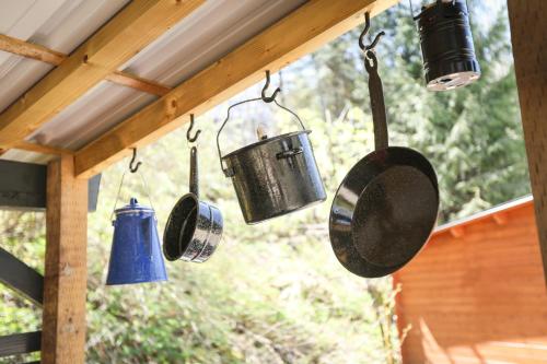 a group of pots and pans hanging from a roof at The Elderberry Cabin - Cowichan Valley Bunkie Glamping in Duncan
