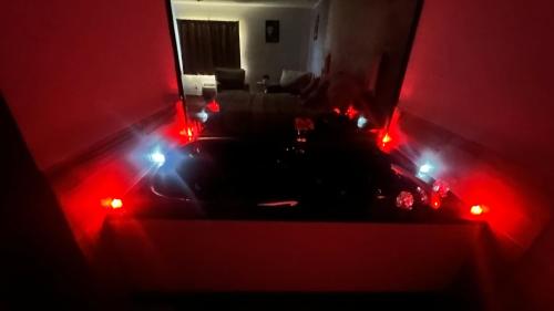 a living room with red lights in a dark room at Chesaning INN & Suites in Chesaning