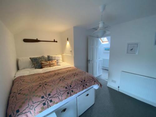 ein Schlafzimmer mit einem Bett mit einer braunen Bettdecke in der Unterkunft Charming, stylish cottage, parking , large private Garden, well located for island highlights in Gaerwen