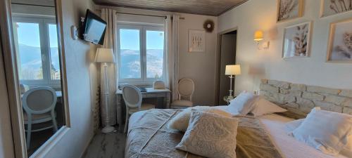a bedroom with a bed and a desk and a window at Les 4 Saisons in Kruth