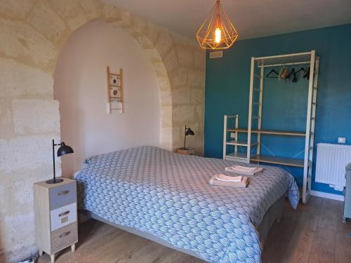a bedroom with a bed with a blue comforter at Domaine Ecoline in Sadirac
