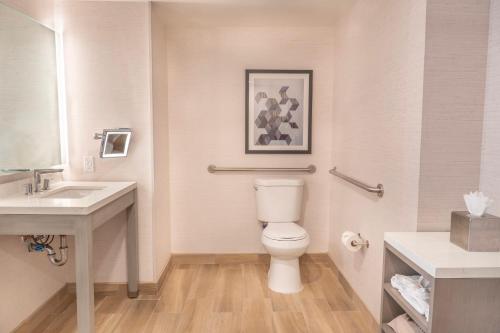 a bathroom with a toilet and a sink at Orange County Hotel in Santa Ana