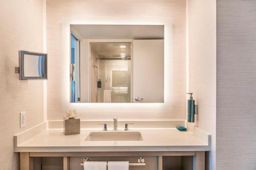 a bathroom with a sink and a large mirror at Orange County Hotel in Santa Ana