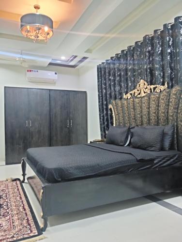 a bedroom with a bed and a black headboard at Haris villa in Dargai
