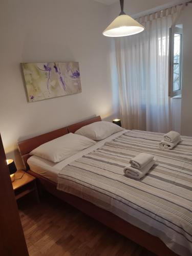 a bedroom with a bed with two towels on it at Biuk Apartments in Novi Vinodolski