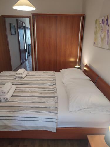 a bedroom with a large bed with two towels on it at Biuk Apartments in Novi Vinodolski