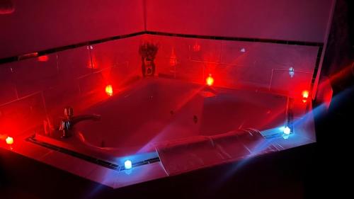 a red bath tub with lights in a bathroom at Chesaning INN & Suites in Chesaning